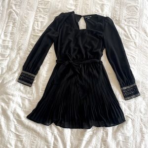 Black semi-formal pleated dress with sheer sleeves and beaded details